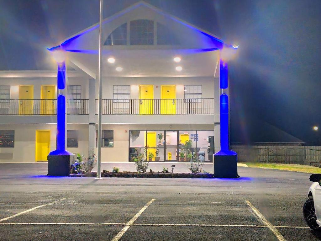 a building with blue lights in a parking lot at SureStay by Best Western McAlester in McAlester
