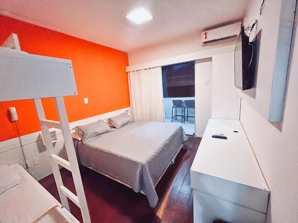 een slaapkamer met een bed met een oranje muur bij Hotel Marinas Tamandaré in Tamandaré