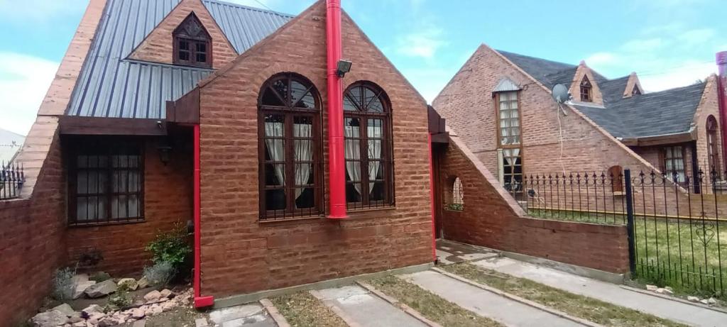 a brick house with a red pole at Aljaba in Esquel