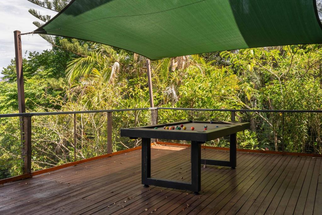 a pool table on a deck with a green canopy at Serenity - Gold Coast hinterland getaway for a couple, family or group in Mount Tamborine