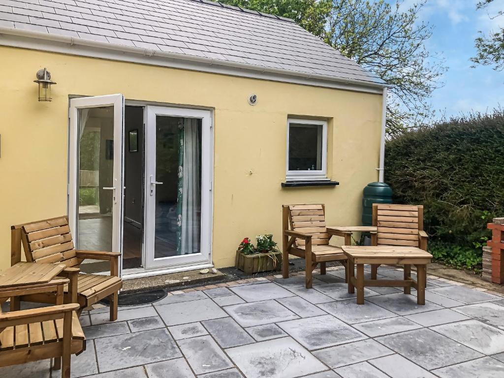 een patio met 2 stoelen en een tafel bij Cowslip Cottage in Roch