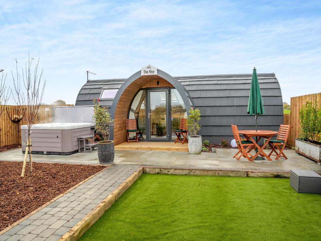 a garden with a house with a lawn at The Hive - Uk45565 in Longford