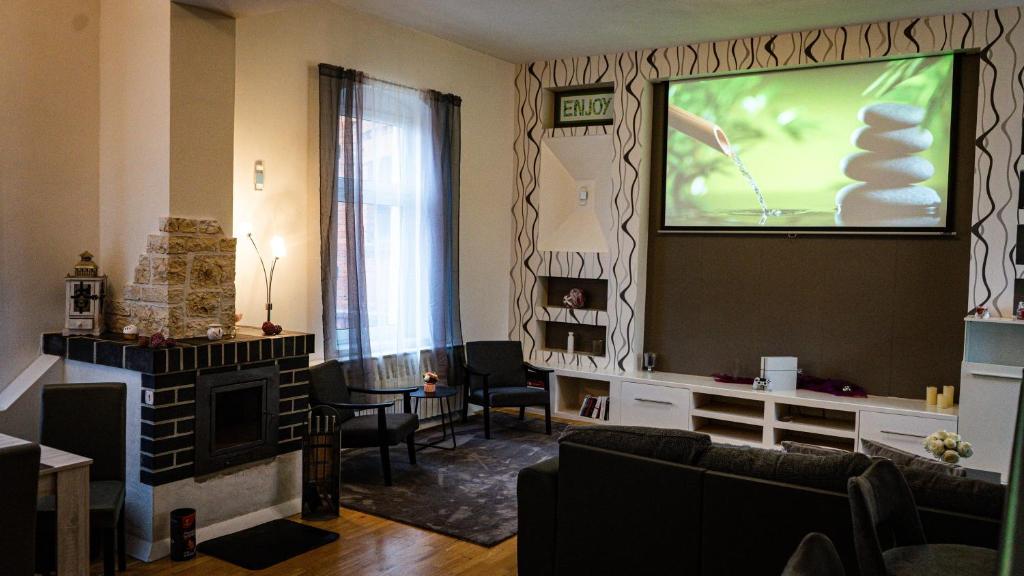 sala de estar con TV y pantalla grande en Ferienwohnung zum alten Hotel, en Gramzow