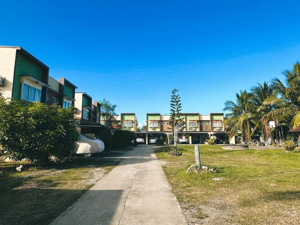 einen Bürgersteig neben einem Gebäude mit Palmen in der Unterkunft Bayan’s 2 storey apartment in Surigao