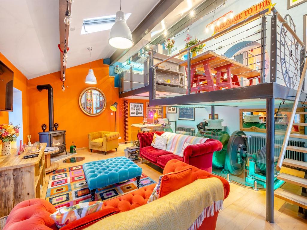 sala de estar con paredes de color naranja y cama elevada en The Engine Room, en Malham