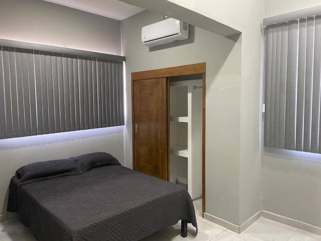een slaapkamer met een bed en airconditioning bij AB bed and breakfast in Chihuahua