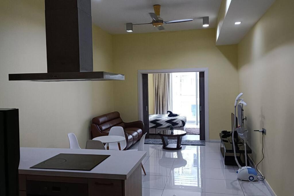 een keuken en een woonkamer met een bank en een tafel bij Cozy M Suites Android Box, Pool and City Area in Kuala Lumpur