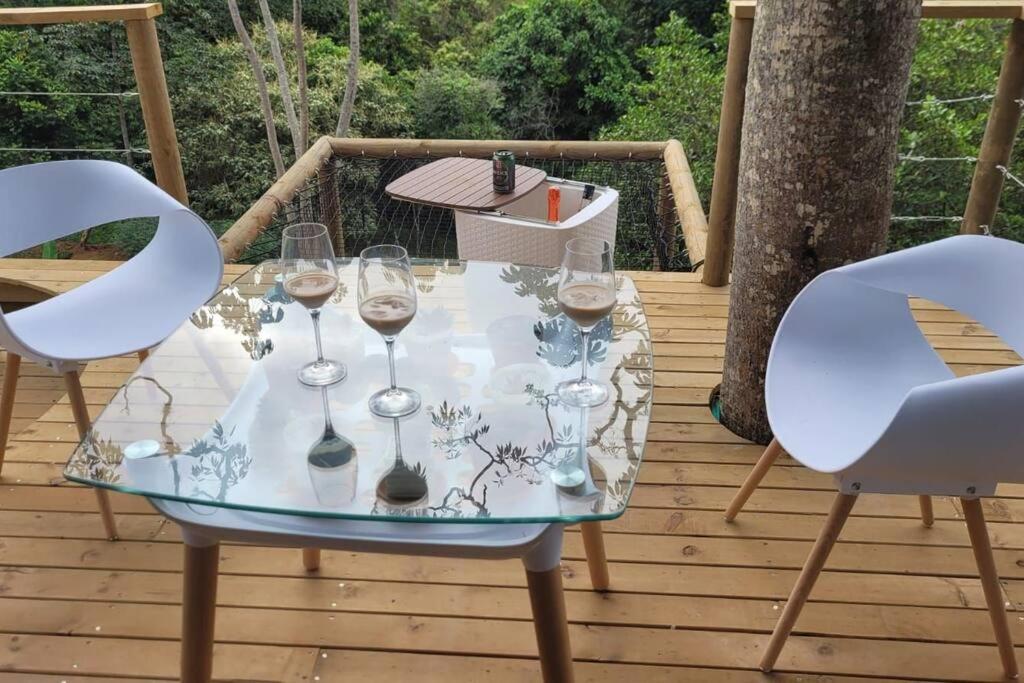 a glass table with wine glasses on a deck at Kuyana Glamping in Cali