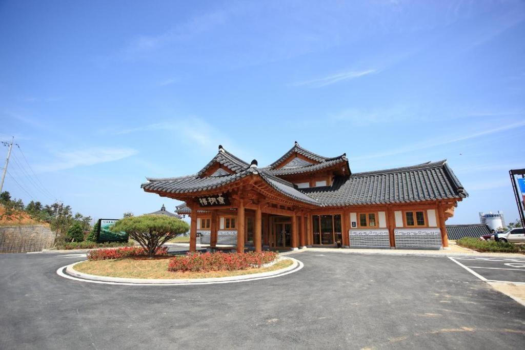 ein großes Gebäude mit Dach auf einem Parkplatz in der Unterkunft Korea Traditional Hotel O Dong Jae in Yeosu