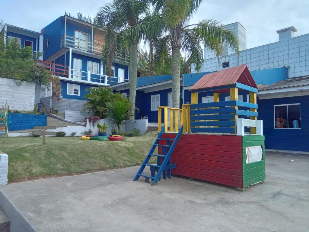 einen Spielplatz vor einem Gebäude mit einem Haus in der Unterkunft Hospedaria Mirante da maré ap6 in Imbituba