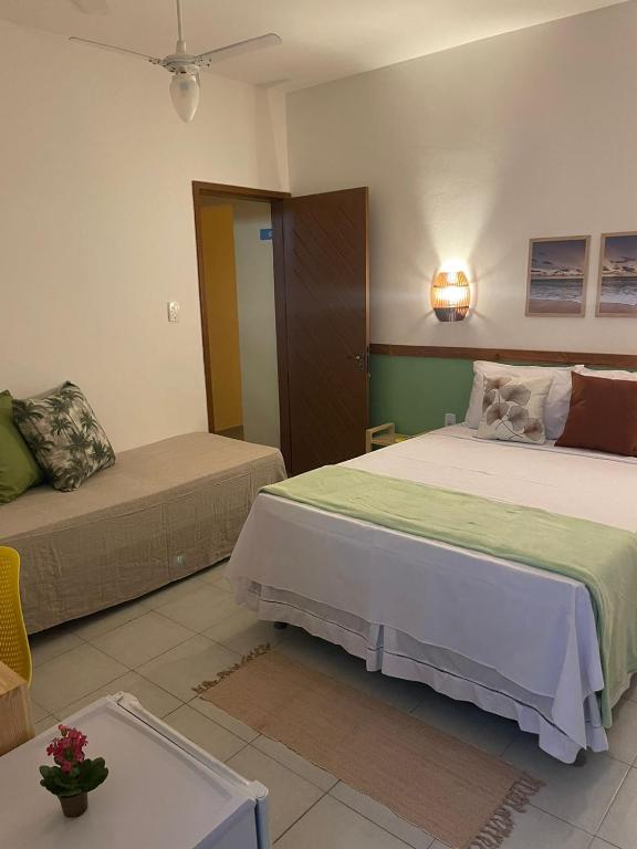 een slaapkamer met 2 bedden en een tafel bij Villa Aconchego Guarajuba in Camaçari
