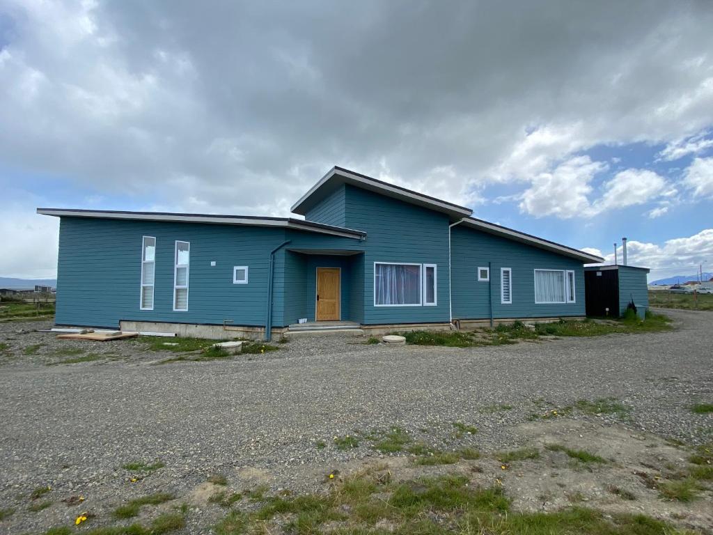 a blue house in the middle of a field at Casa Patagonia in Puerto Natales