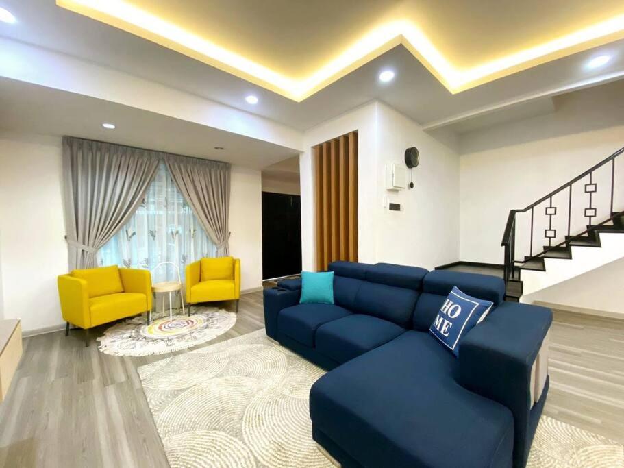 sala de estar con sofá azul y sillas amarillas en Modern Cozy House 4Room10pax @Near Sunway Carnival en Perai