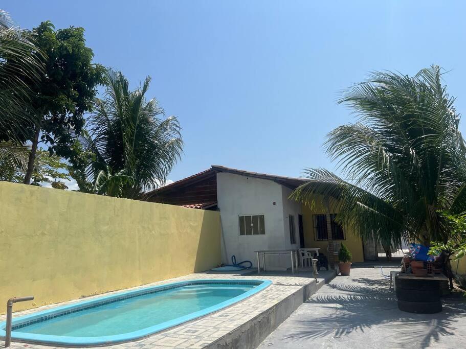 una piscina di fronte a una casa con palme di Casa com piscina em Tutóia a Tutóia