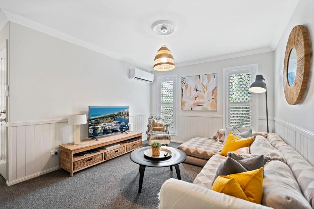 a living room with a couch and a tv at Charming 3-Bedroom Townhouse with Private Courtyard in Brisbane