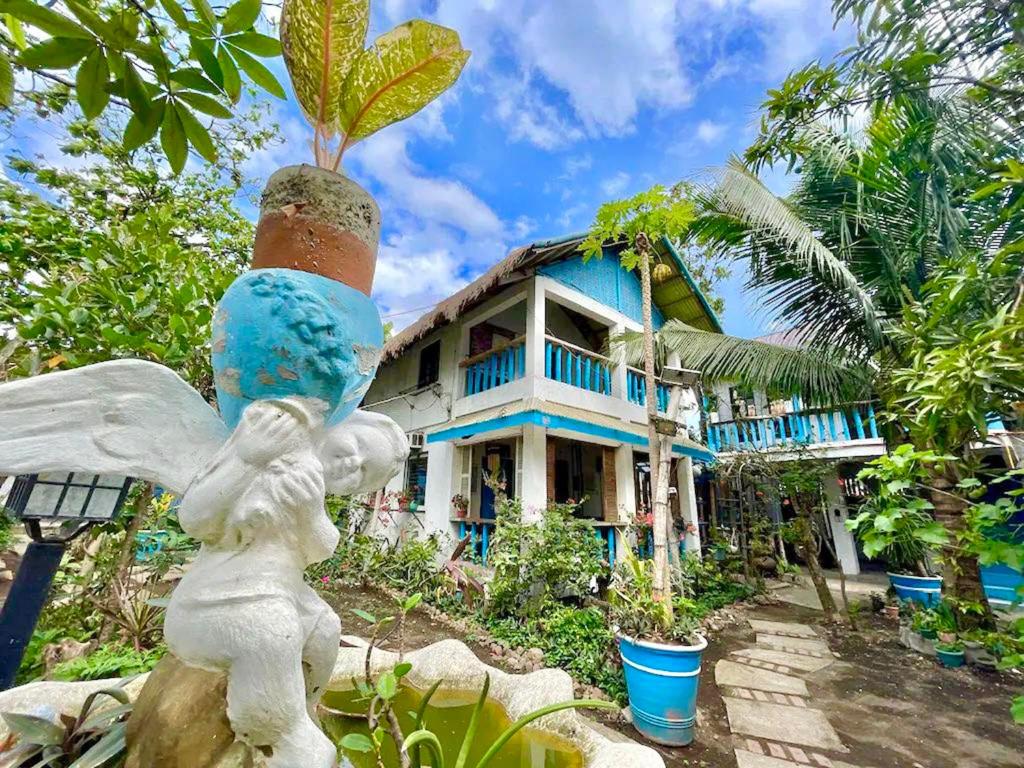 a statue of an angel in front of a house at Half Moon Village and Beach House powered by Cocotel in Campo