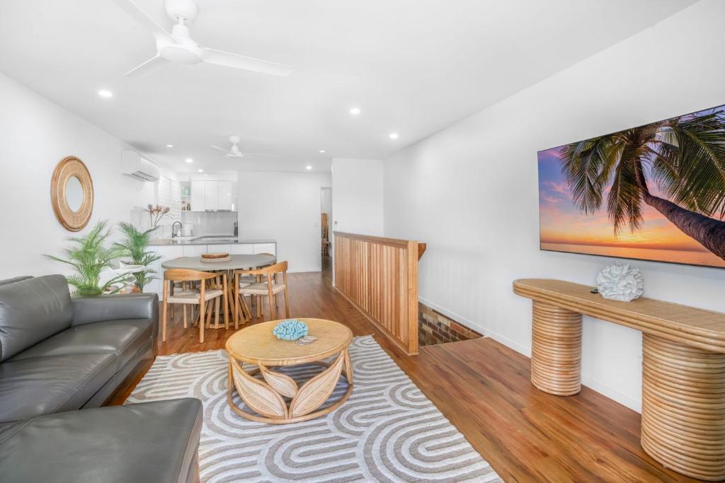 a living room with a couch and a table at 1-46 Manooka Drive - Rainbow Beach Aircon. Wifi. Pool. View in Rainbow Beach