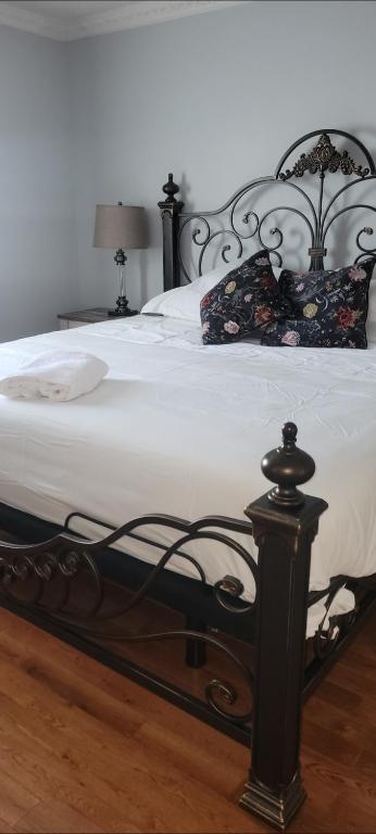 a black and white bed with a white blanket and pillows at Chambre Royale in Ottawa