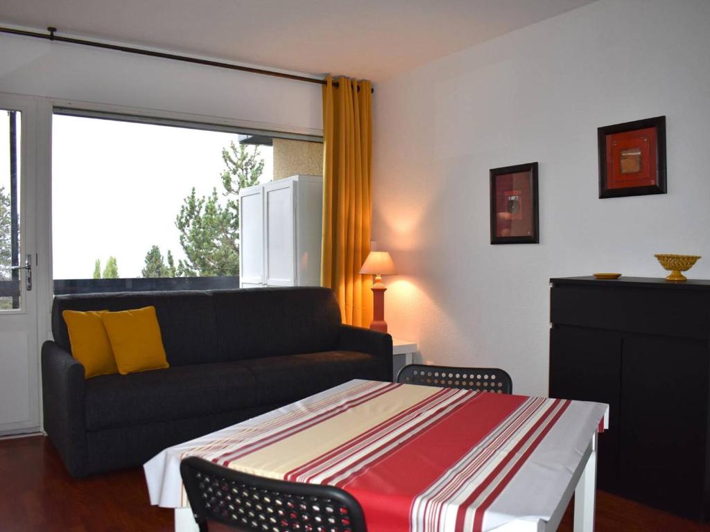 a living room with a couch and a table at Studio Font-Romeu-Odeillo-Via, 1 pièce, 2 personnes - FR-1-580-102 in Font-Romeu-Odeillo-Via