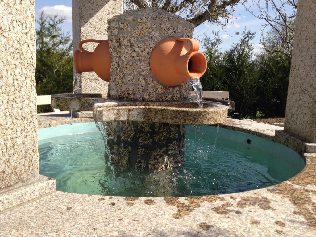 a water fountain with a statue of a pig at Gites Des Sablons in Châtillon-sur-Marne