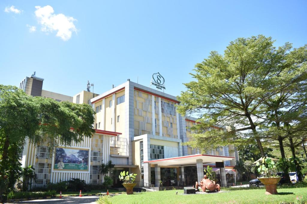 un bâtiment avec un parc en face dans l'établissement Syariah Hotel Sentul, à Bogor