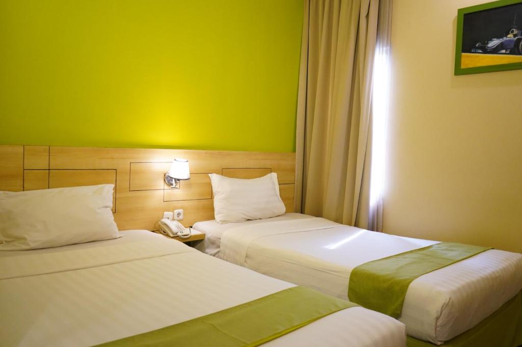 Postel nebo postele na pokoji v ubytování Lorin Syariah Hotel Sentul