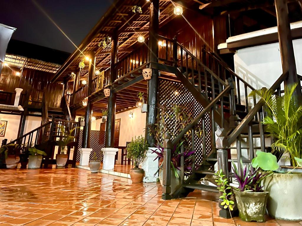 a lobby with potted plants and stairs in a building at Vieng Savanh II Hotel in Luang Prabang