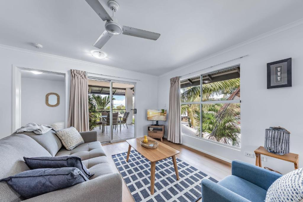 uma sala de estar com um sofá e uma mesa em Casa Ava Airlie em Airlie Beach