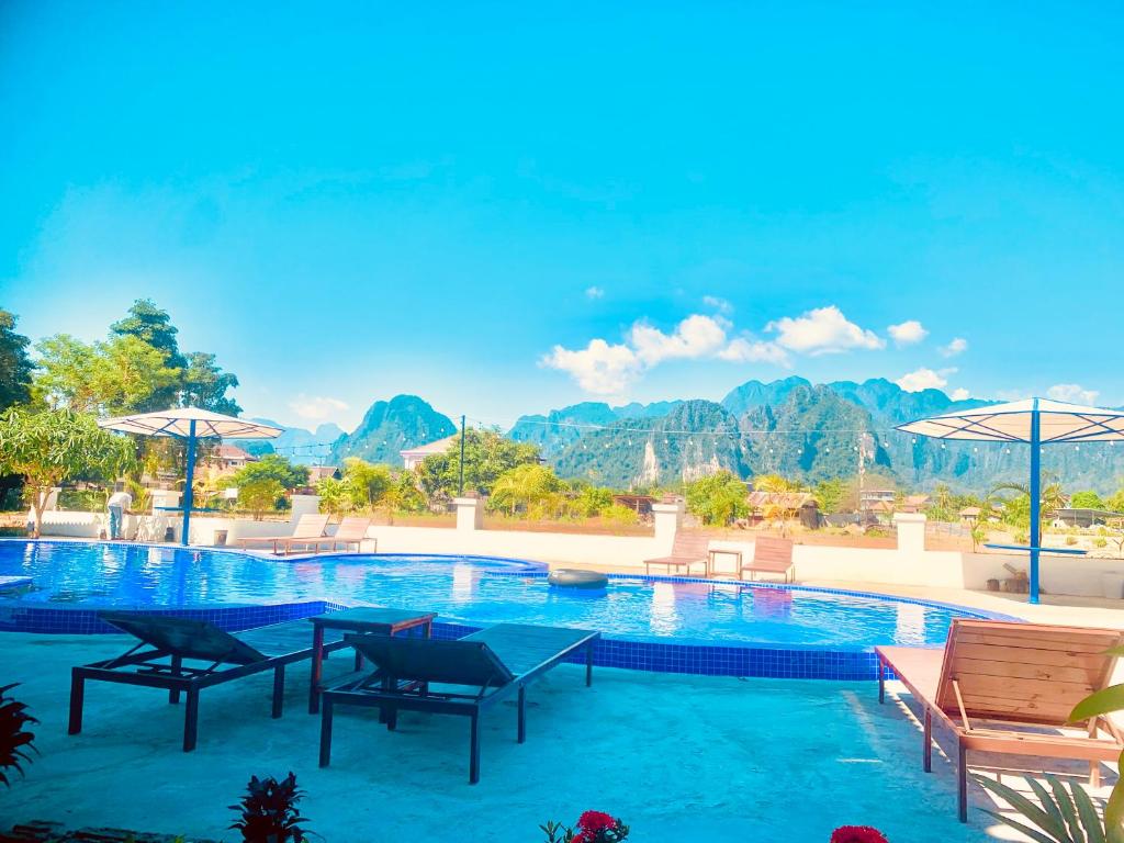 une piscine dans un complexe avec des montagnes en arrière-plan dans l'établissement Garden Resort, à Vang Vieng