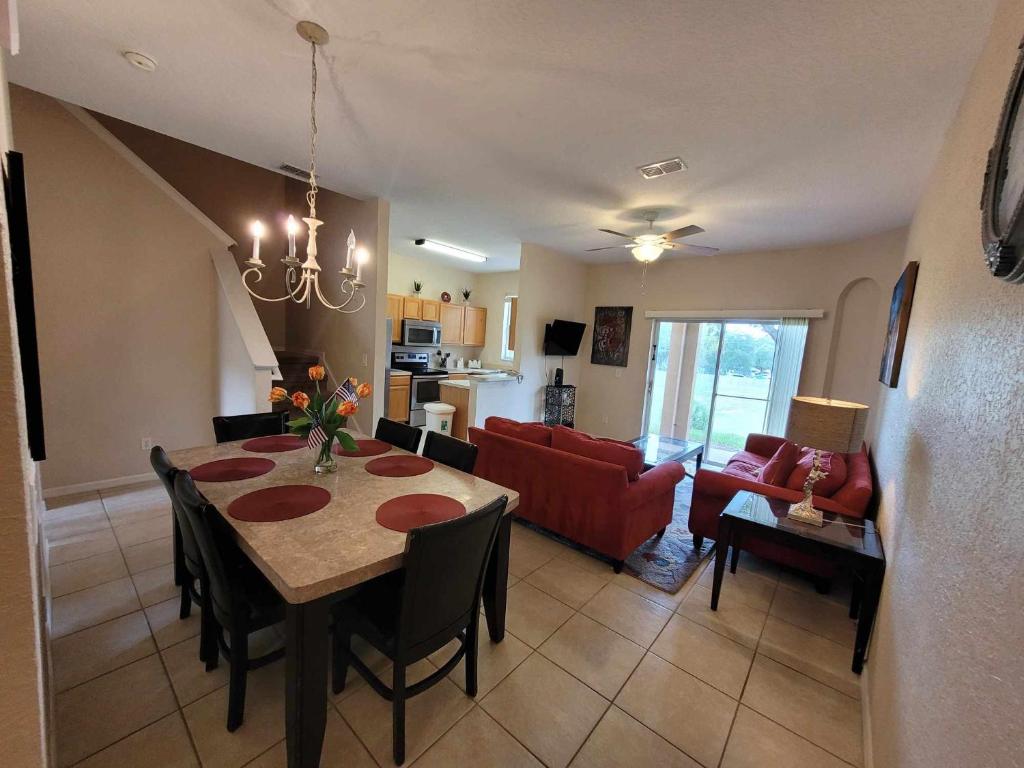 a dining room and living room with a table and chairs at Townhouse in Regal Palms Resort, Amenities, Pool & lazy river, Near Disney, Orlando in Davenport