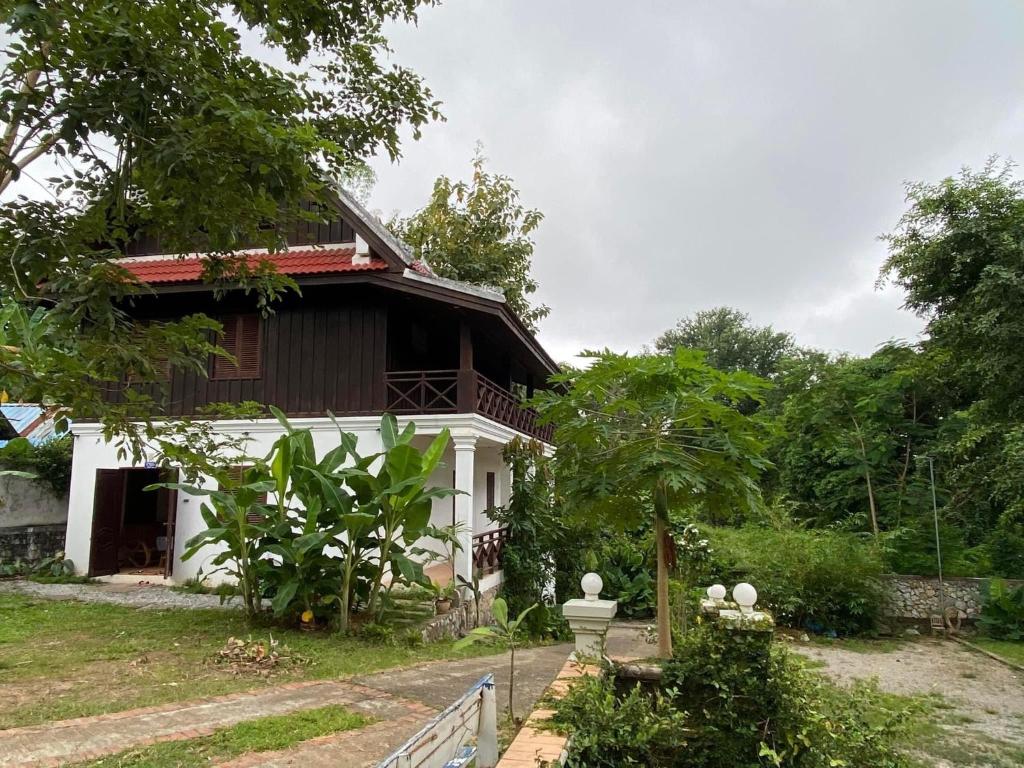 Biały dom z płotem przed nim w obiekcie Mary’s Home Stay w mieście Luang Prabang
