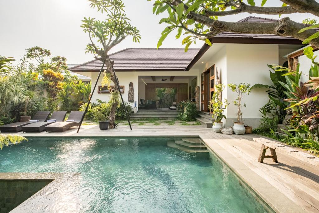 a villa with a swimming pool and a house at Villa Nya Ubud in Ubud
