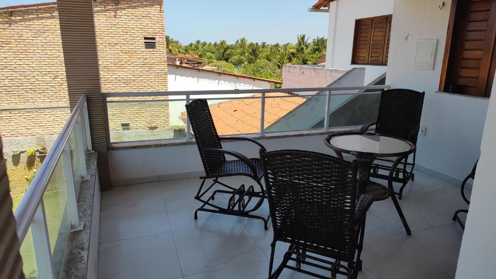 a balcony with chairs and a table on a balcony at Casa Tropicana (2º andar) in Flecheiras