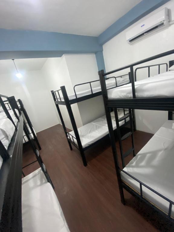 a room with three bunk beds in a dorm at Lime Lite Manila Hostel in Manila