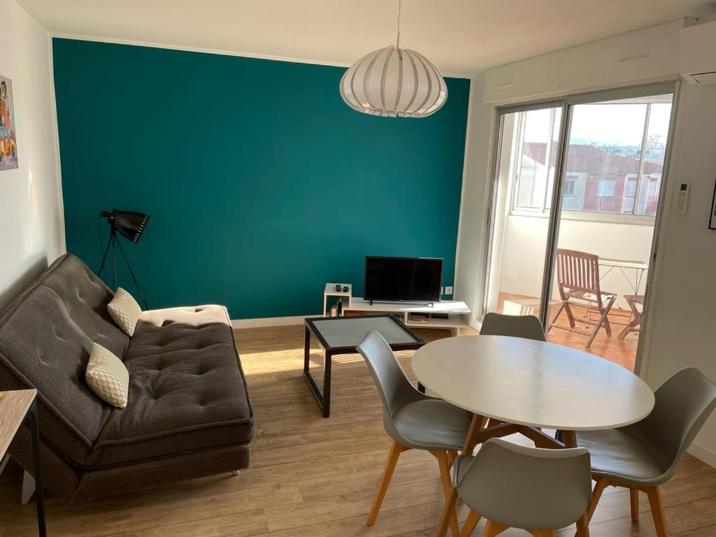 uma sala de estar com um sofá e uma mesa em T2 55m2 Perpignan proche centre ville et gare avec parking em Perpignan