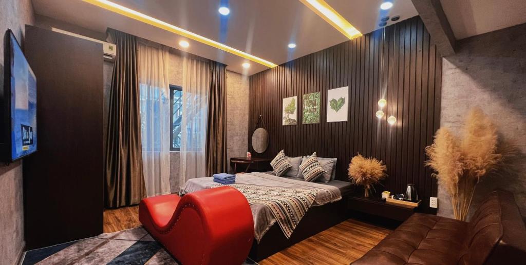 um quarto com uma cama e uma cadeira vermelha em MIS HOSTEL Cần Thơ em Can Tho
