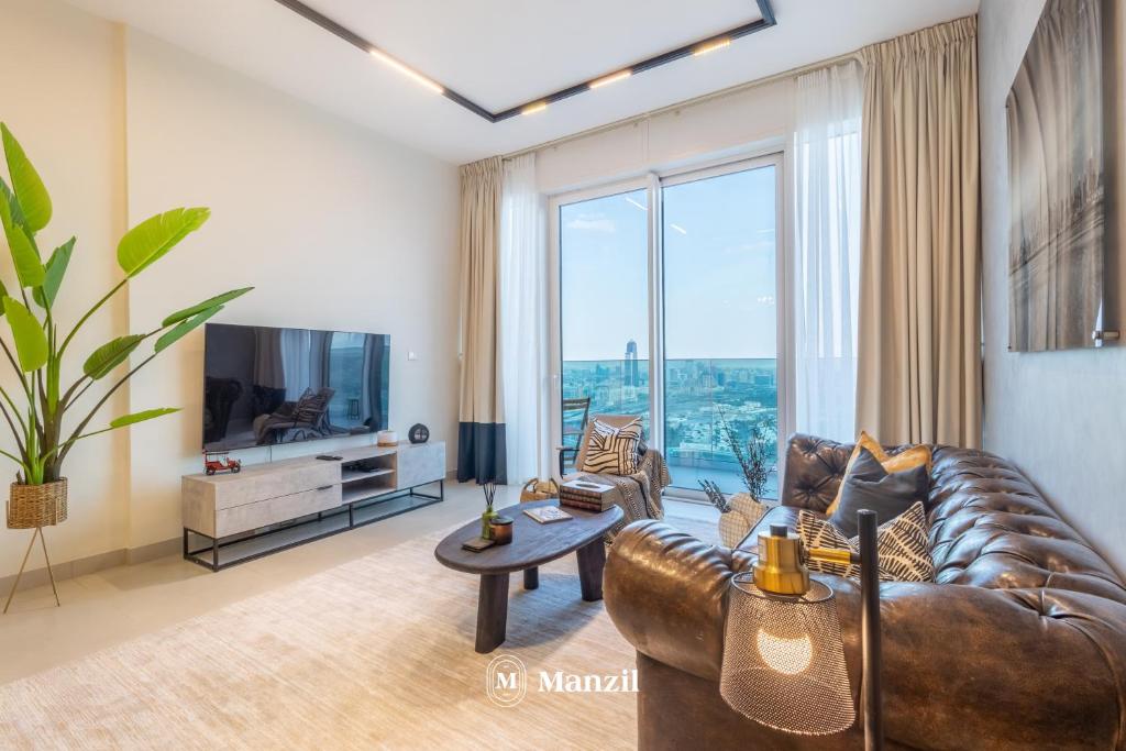 a living room with a leather couch and a television at Manzil - 2BR Apt in Al Wasl Residences with Park View, Dubai Trade Center in Dubai