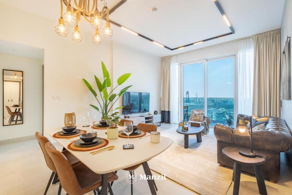 a dining room and living room with a table and chairs at Manzil - 2BR Apt in Al Wasl Residences with Park View, Dubai Trade Center in Dubai