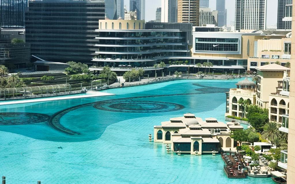 a large pool with blue water in a city at Fountainview Luxe 1BR, sleeps 4 in Dubai