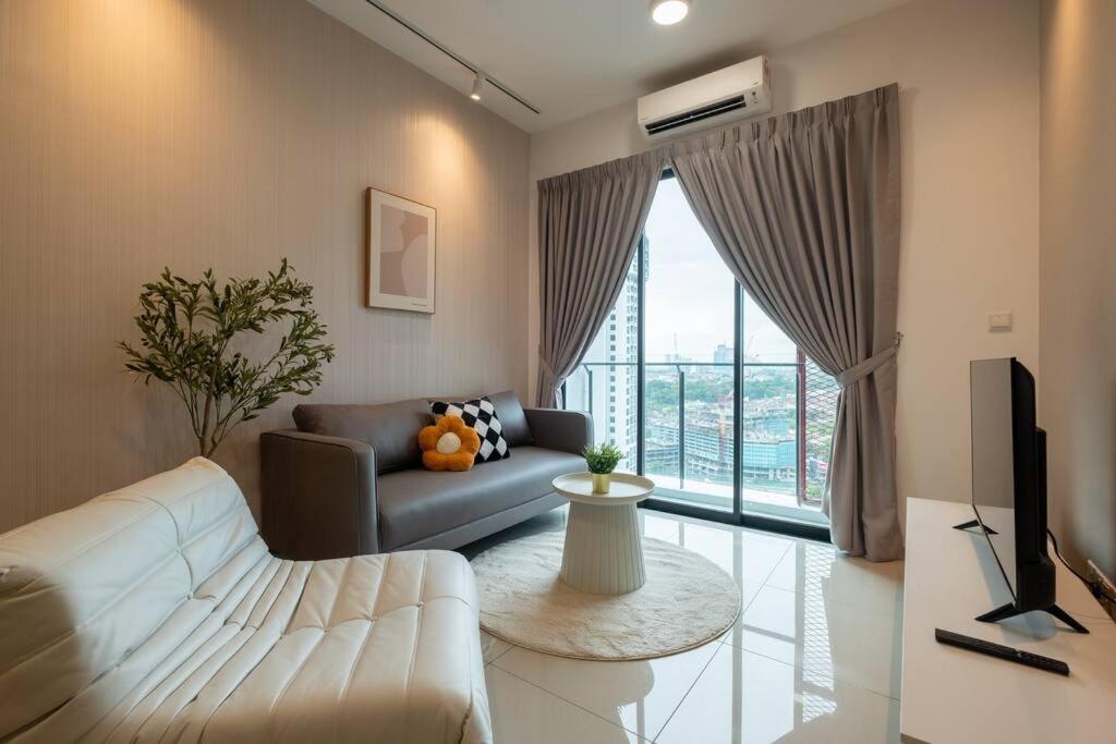 a living room with a white couch and a large window at Blissful Cottage@FeelHome/2BR,7pax,MRT 中文房东 in Kuala Lumpur