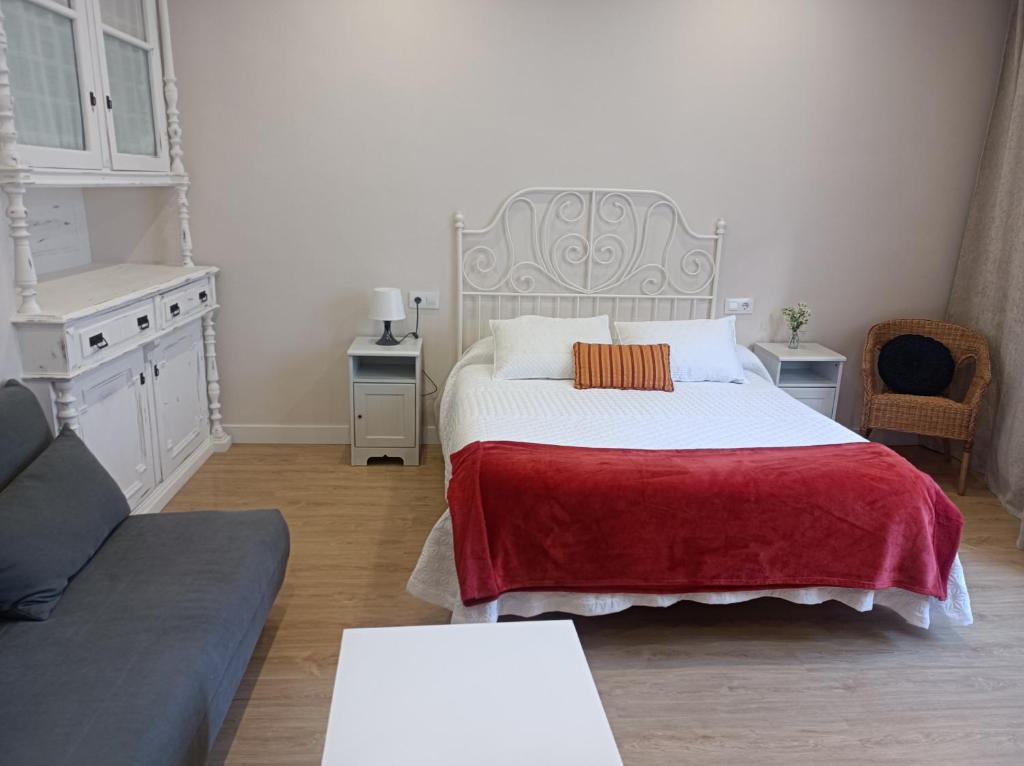 1 dormitorio con 1 cama con manta roja en TraviesaBetanzos, en Betanzos