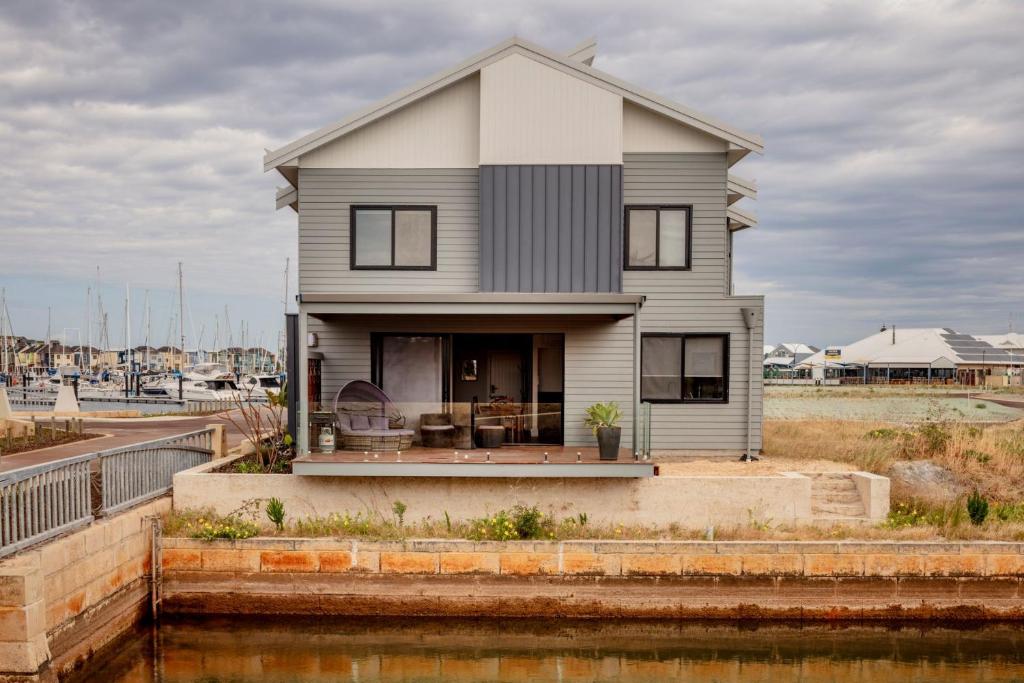 a house sitting on top of a body of water at Port Lane Lower Apartment in Geographe