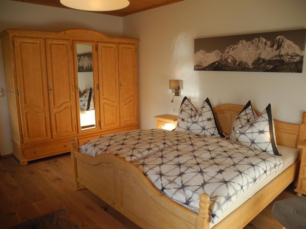 une chambre avec un lit et une armoire en bois dans l'établissement Appartement Bichler Rosi, à Söll