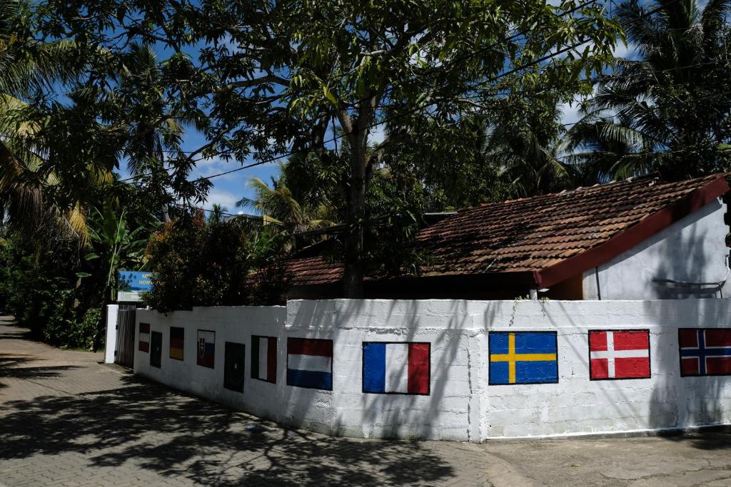 une maison avec des fenêtres colorées sur son côté dans l'établissement MENAKA HOMESTAY, à Tangalle