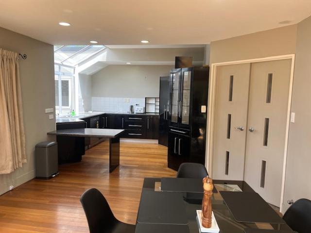 a kitchen with a black refrigerator and a table at Marvelous Munro in Hamilton