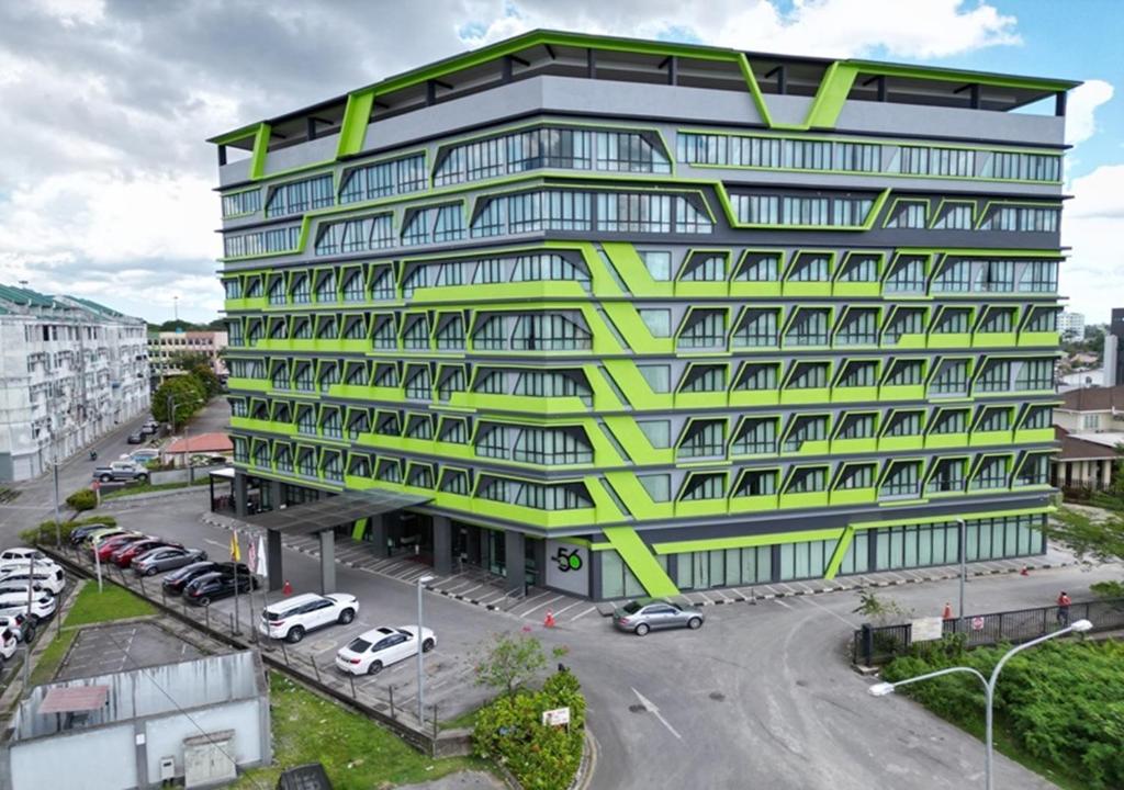 un edificio con uffici di colore giallo e verde di 56 Hotel a Kuching