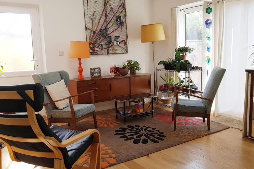 a living room with two chairs and a table at Comfortable artistic house welcomes you! in Oxford