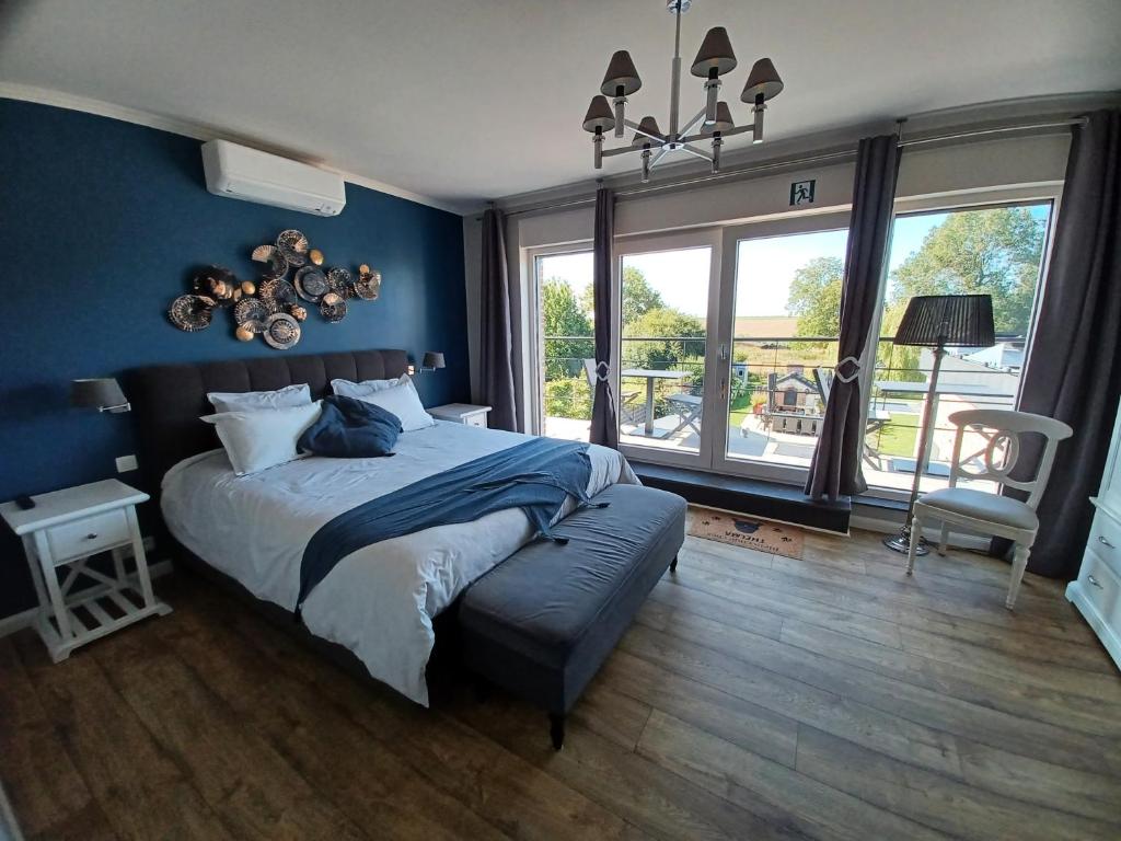 una camera da letto con un letto grande con una parete blu di B&B La source de notre Manon a Jauche