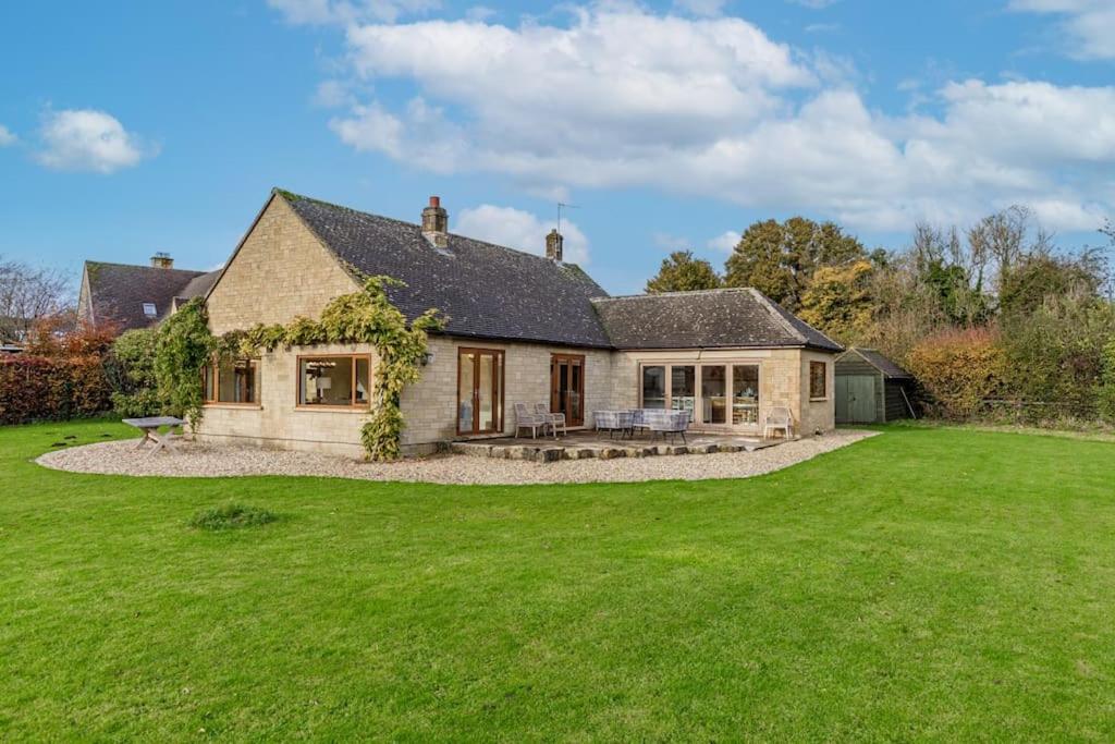 a house with a large lawn in front of it at Charming 3BD Cotswolds Family Retreat in Bourton on the Water