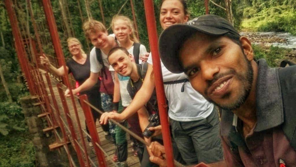 eine Gruppe von Personen auf einer Hängebrücke in der Unterkunft Sinharaja Hostel in Deniyaya